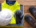 Photo of various items of protective clothing arranged on a wooden table top