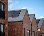 Photo of solar panels on the pitched roof of a new housing development