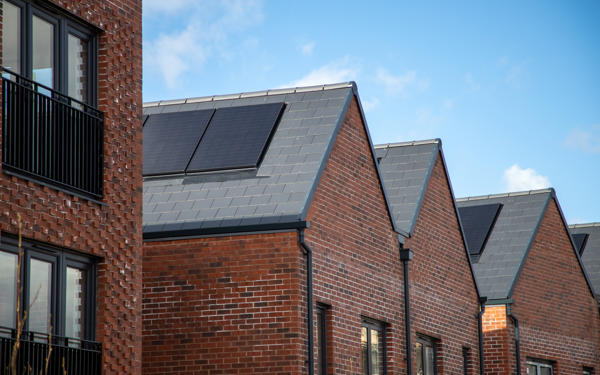 Photo of solar panels on the pitched roof of a new housing development