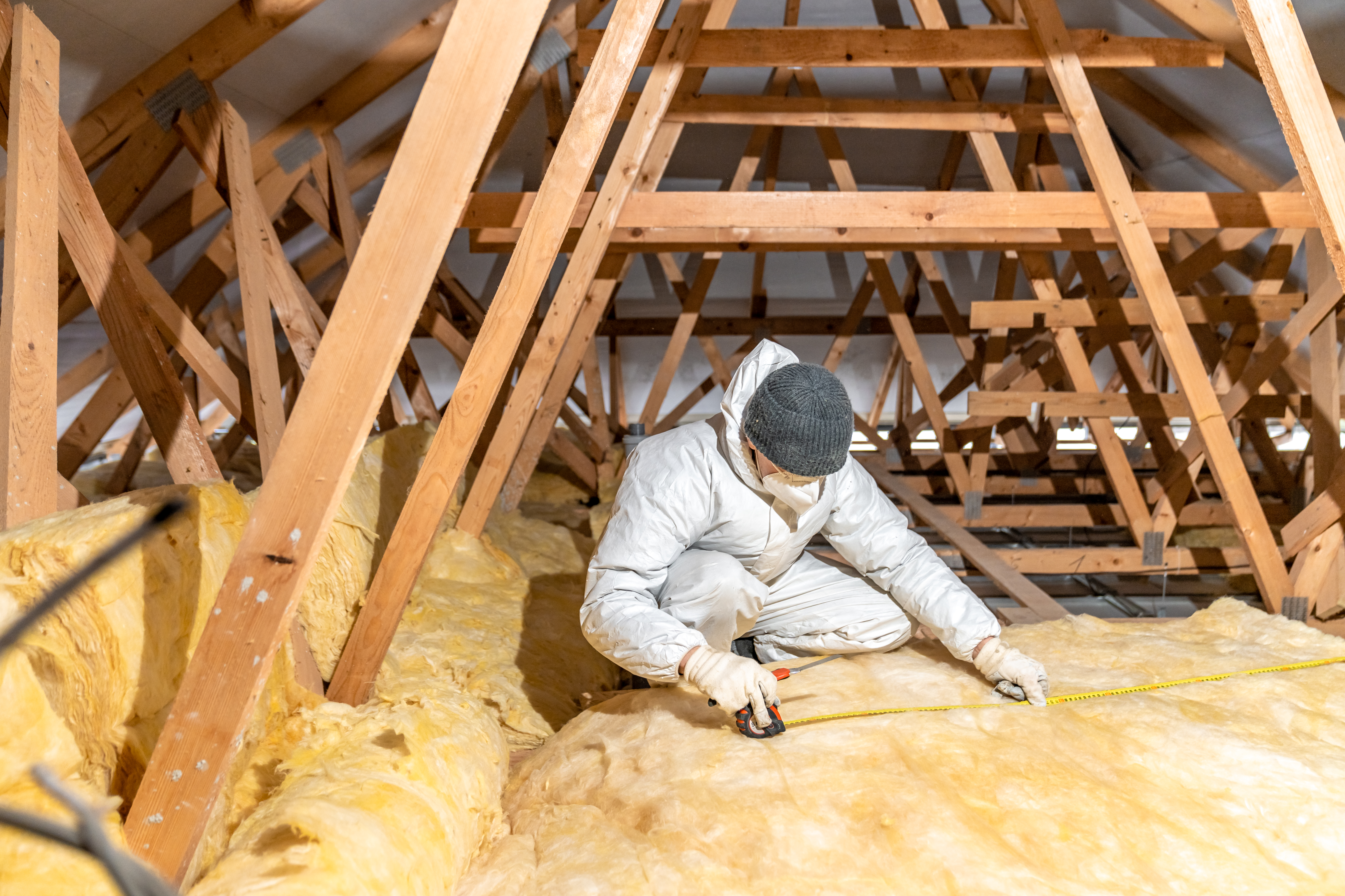 Photo of a man in protective clothing fitting loft insulation