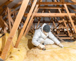 Photo of a man in protective clothing fitting loft insulation