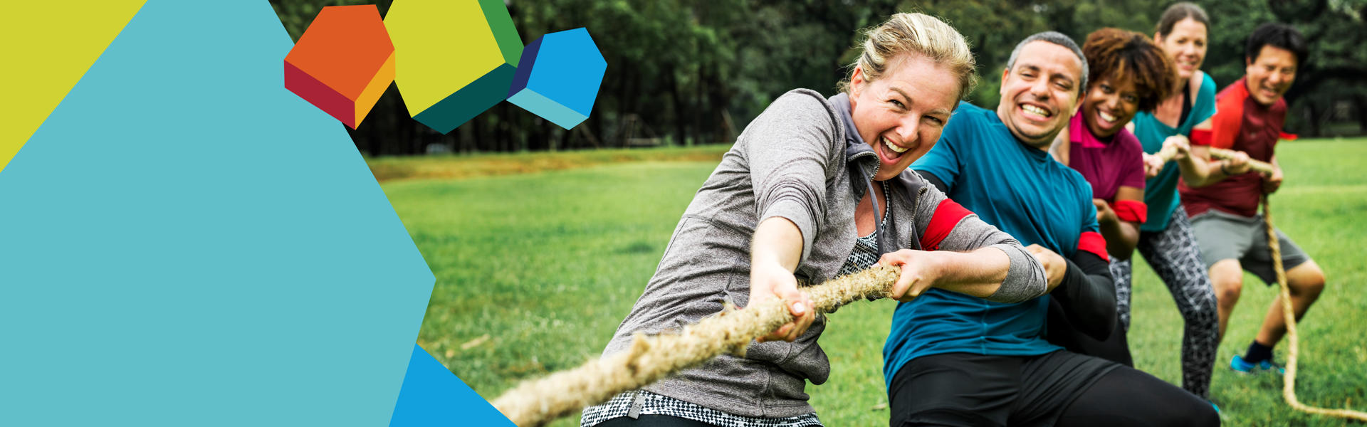 Photo of five people of various ages taking part in a tug of war - they are pulling the rope away from the viewer