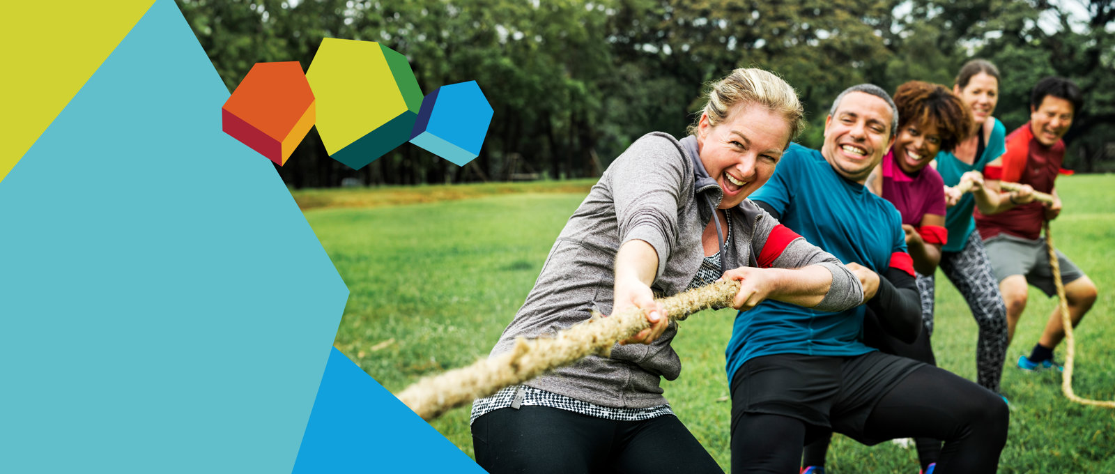 Photo of five people of various ages taking part in a tug of war - they are pulling the rope away from the viewer