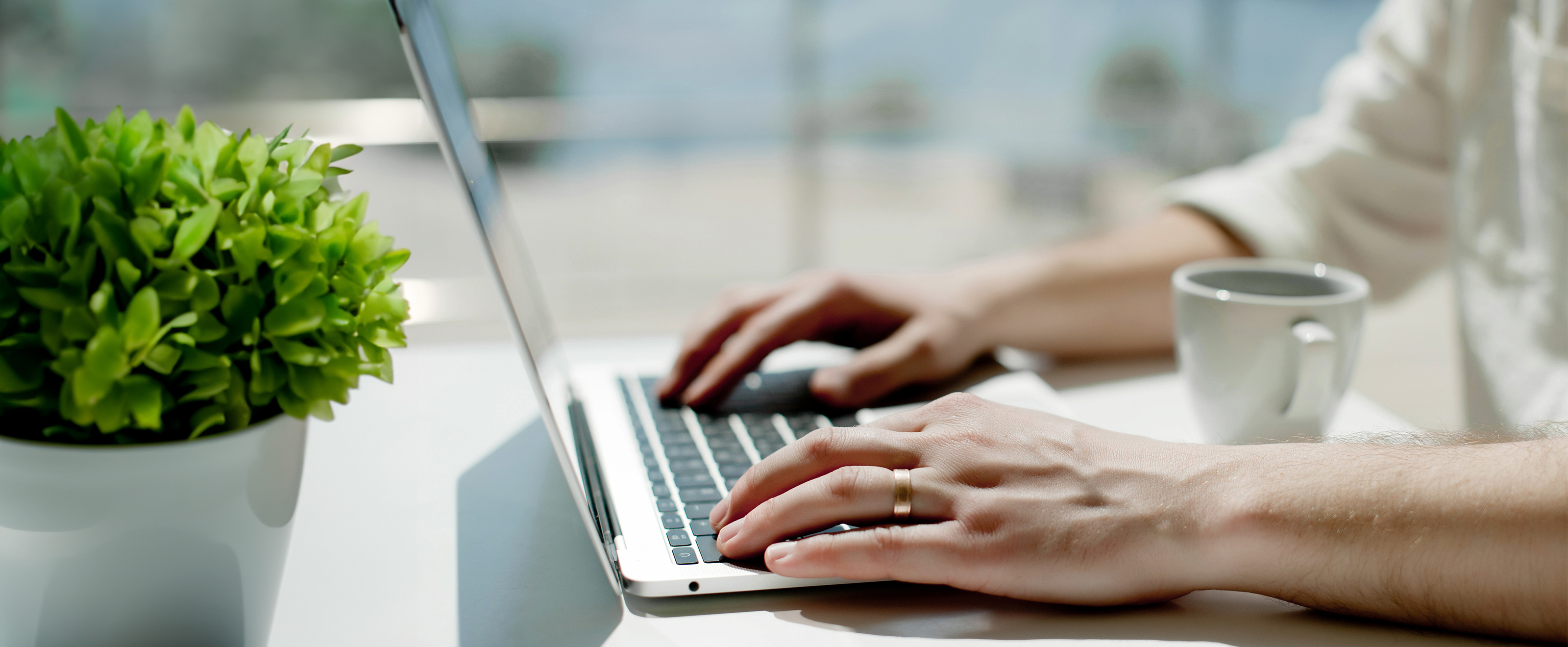 Close up photo of a woman typing on a laptop keyboard