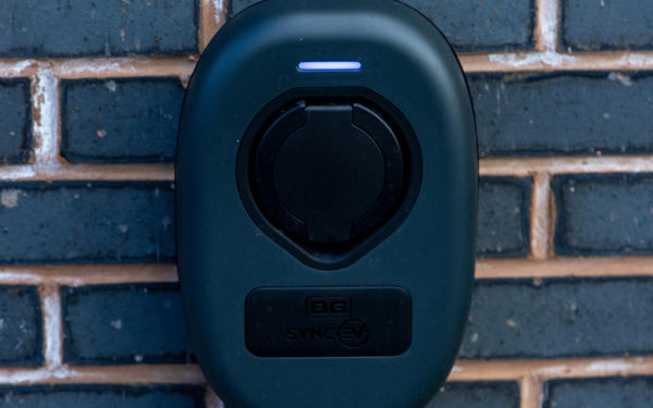 close up view of an electric car charging point on an exterior brick wall