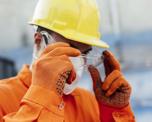 Workman In Hard Hat Adjusting Goggles