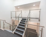 Photo of an interior stairway with contemporary metal and glass ballustrades