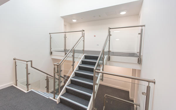 Photo of an interior stairway with contemporary metal and glass ballustrades