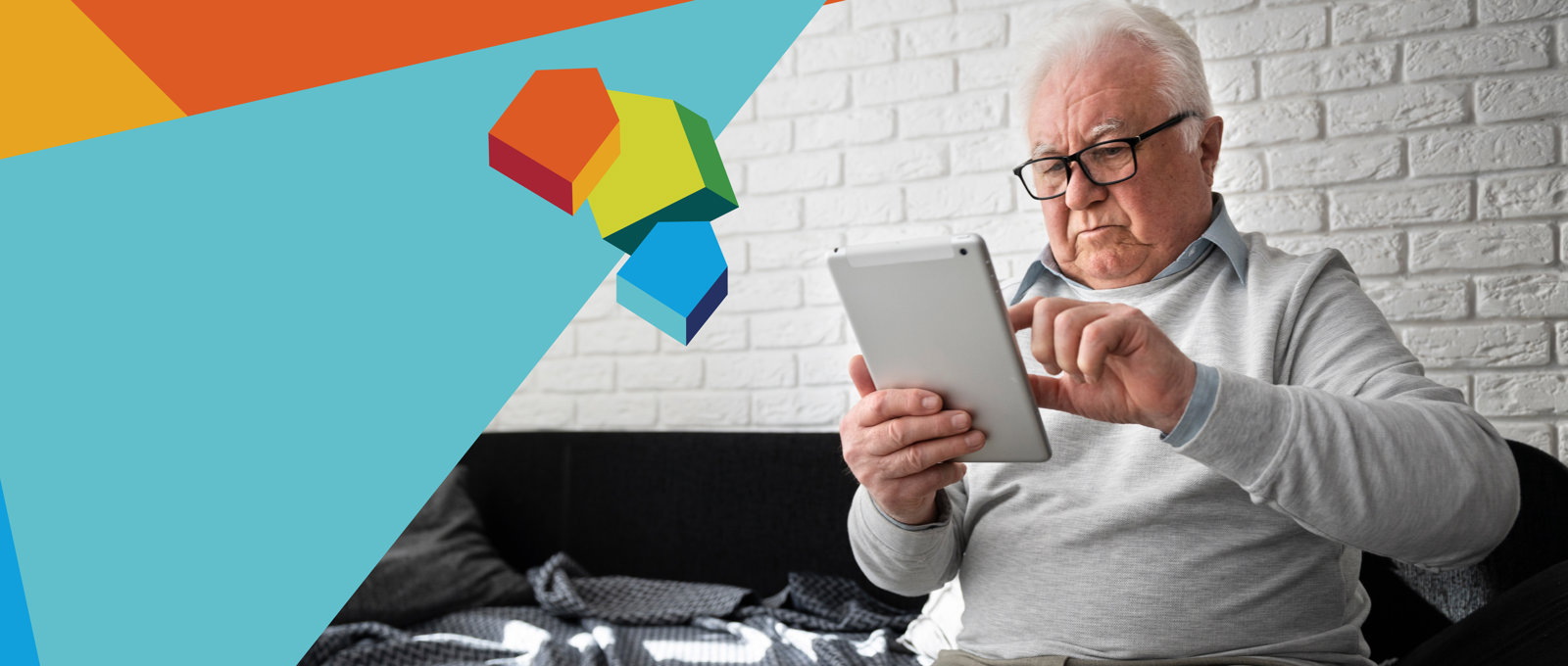 Photo of an older man using a tablet computer while sitting on a sofa